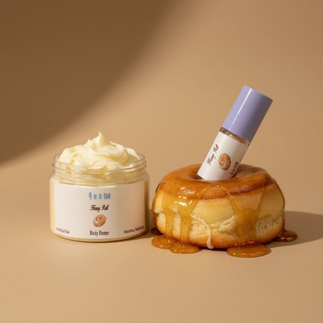 Jar of body butter and a bottle with a roll-on applicator on a honey-drenched bun against a beige background.